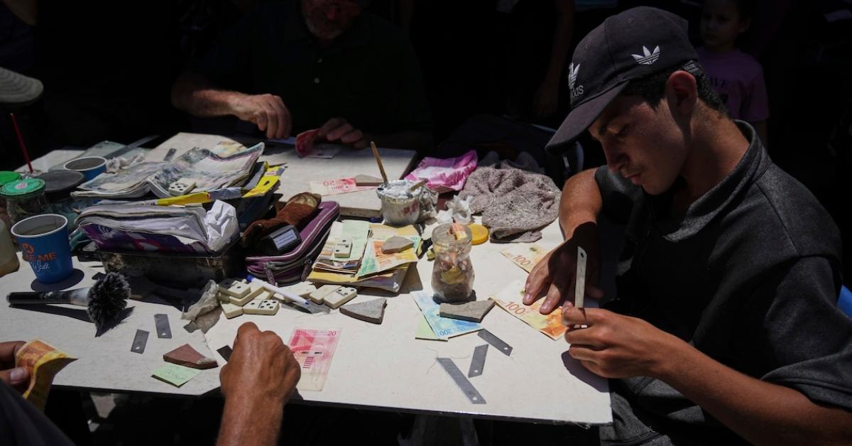 gaza palestinesi incollano banconote rotte a causa del blocco del contante imposto da israele sportelli e banche distrutti da raid idf