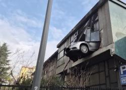 Milano, 84enne rimasto sospeso con auto a 8m d’altezza dopo manovra sbagliata in autorimessa al primo piano, sfondato muro vetrato - VIDEO