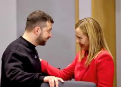 Bruxelles, il guitto Zelensky non si ferma: imbraccia armi e abbraccia la Meloni