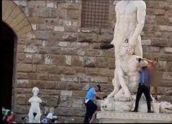 Firenze, uomo nudo e con scritta "censurato" si arrampica su statua di Ercole e Caco in piazza Signoria - VIDEO
