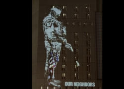 Omicidio Minneapolis, agente ICE bendato spara su "madri, bambini, democrazia, diritti": il VIDEO di protesta proiettato sul carcere a LA