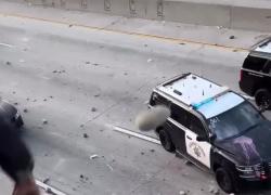 Proteste Los Angeles, massi e monopattini elettrici gettati da un ponte su auto della polizia da manifestanti incappucciati - VIDEO