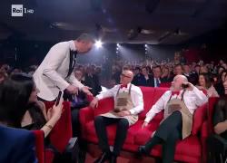 Sanremo, gaffe di Amadeus col presidente di Rai Cinema Nicola Claudio: lo scambia per uno spettatore e si siede sulle sue gambe - VIDEO