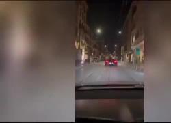Milano, parla al telefono seduto sul cofano di una Ferrari in movimento - VIDEO 