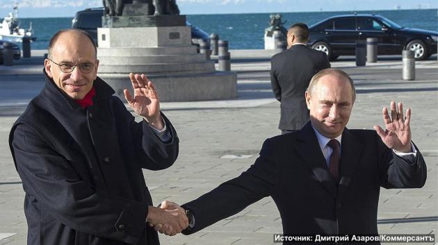 Enrico Letta e Vladimir Putin si stringono la mano e sorridono insieme