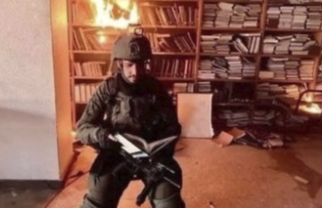 Un soldato israeliano brucia dei libri nella biblioteca dell'universit&agrave; Al-Aqsa di Gaza - Foto: X