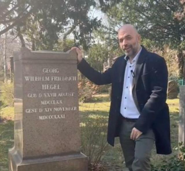 Il bardo cosmopolita Roberto Saviano sulla tomba di Hegel: una scena comica, data la contrapposizione evidente tra il pi&ugrave; grande filosofo moderno e l'araldo del pensiero unico politicamente corretto