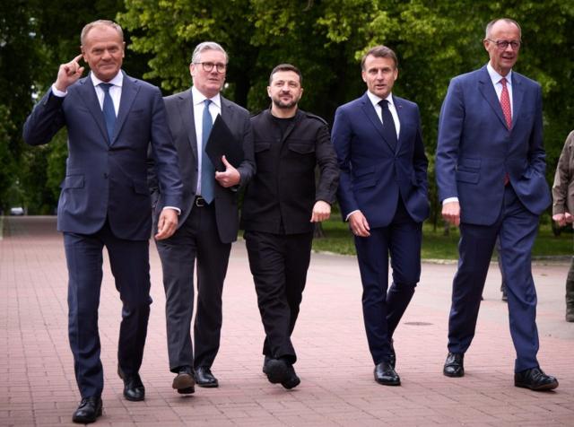 Ucraina, i 4 sciamannati Macron, Merz, Starmer e Tusk a Kiev con Zelensky nel Giorno della Vittoria sul nazismo: una patetica controfesta